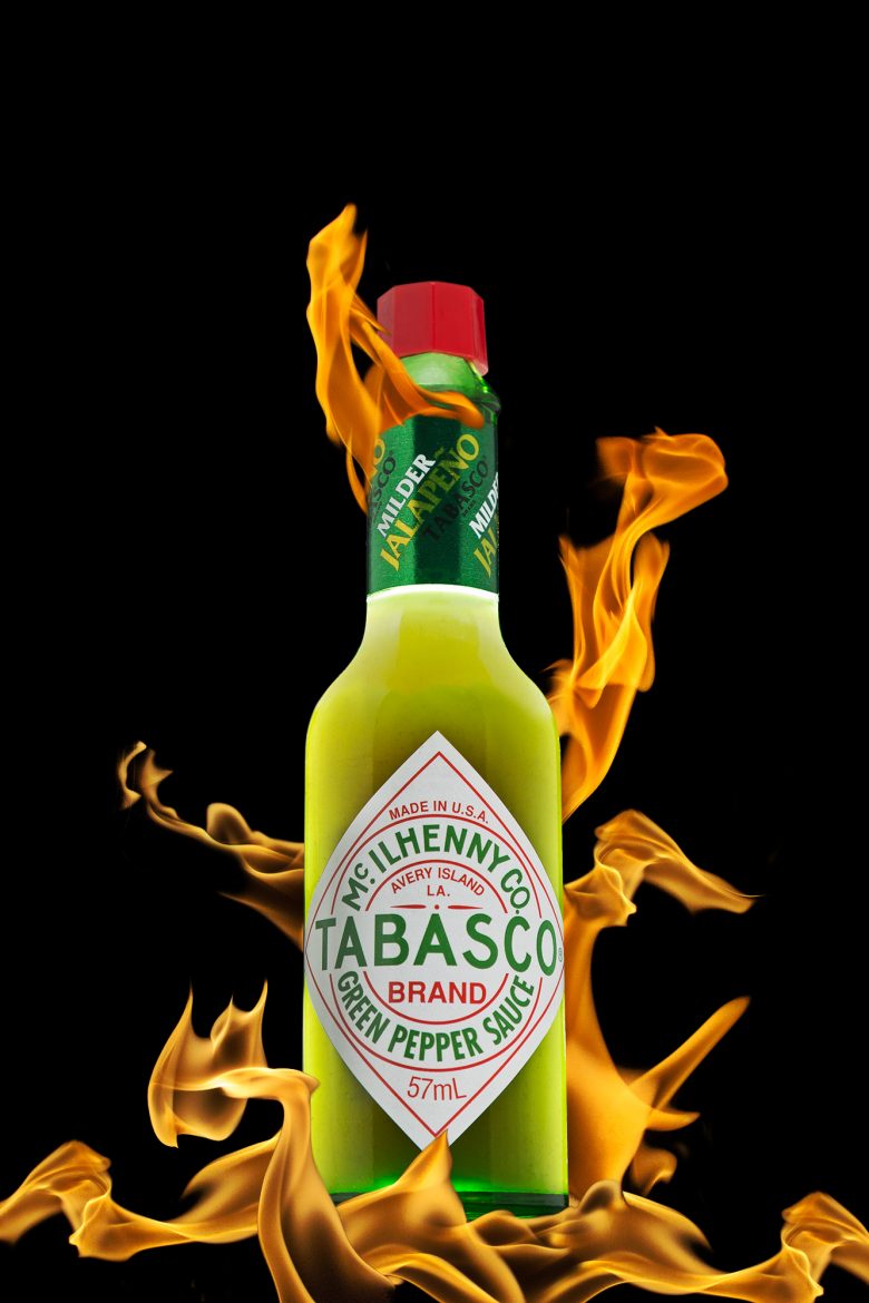 Image composite mettant en scène une bouteille de tabasco vert et des flammes