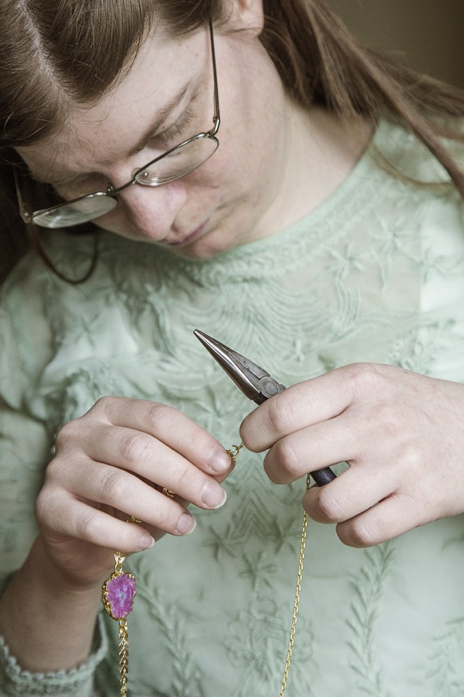 Fanny concentrée lors de l'assemblage d'un collier.