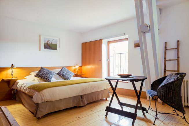 Domaine de La Reculée, photographie d'intérieur du gîte et des chambres d'hôtes. Vue d'ambiance de la chambre djoliba aux accent maliens et au ton jaune. Cette chambre est située à l'étage.