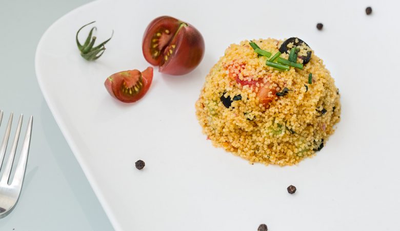 Portion de taboulé maison accompagné d'une tomate cerise.